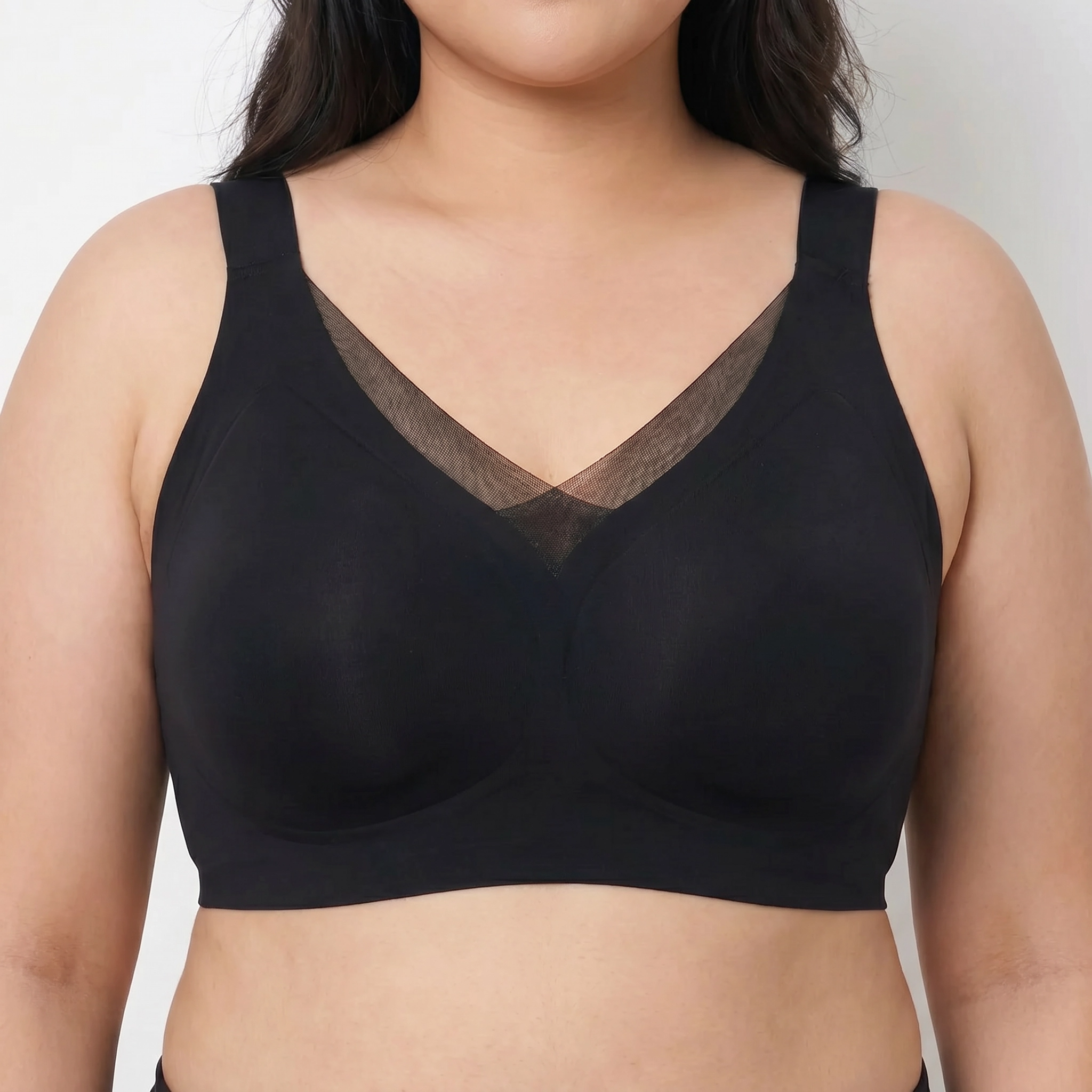 Black bra worn by a person on a plain background